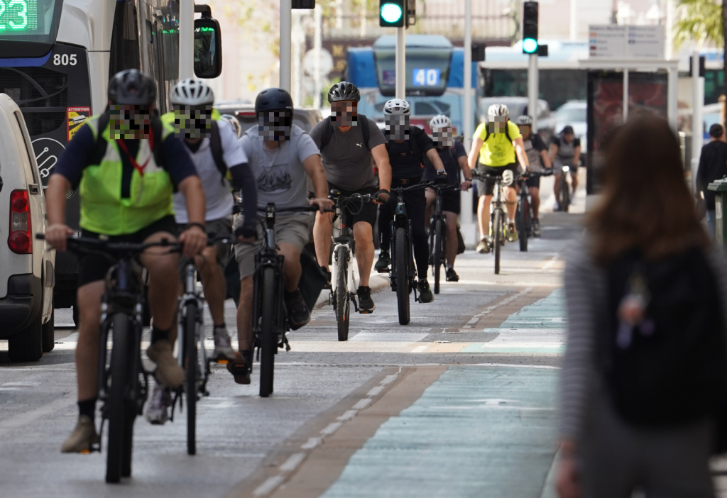 Photo le long de l'avenue de la république. Sur la piste, 8 cyclistes sont visibles, les visages pixelisés.